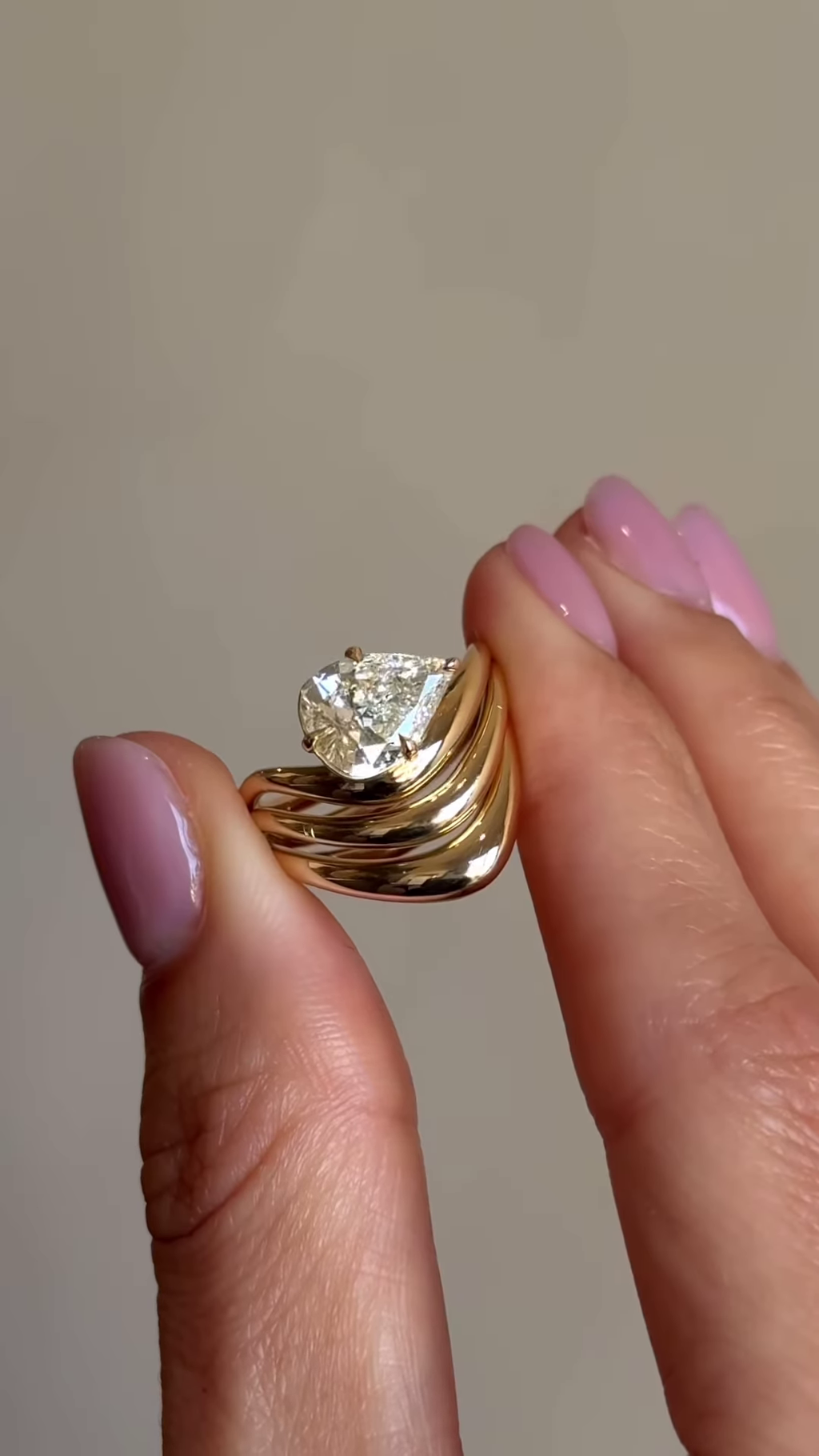 Sculptural Gold-Toned Ring with Wavy Design and Pear-Shaped Clear Gemstone