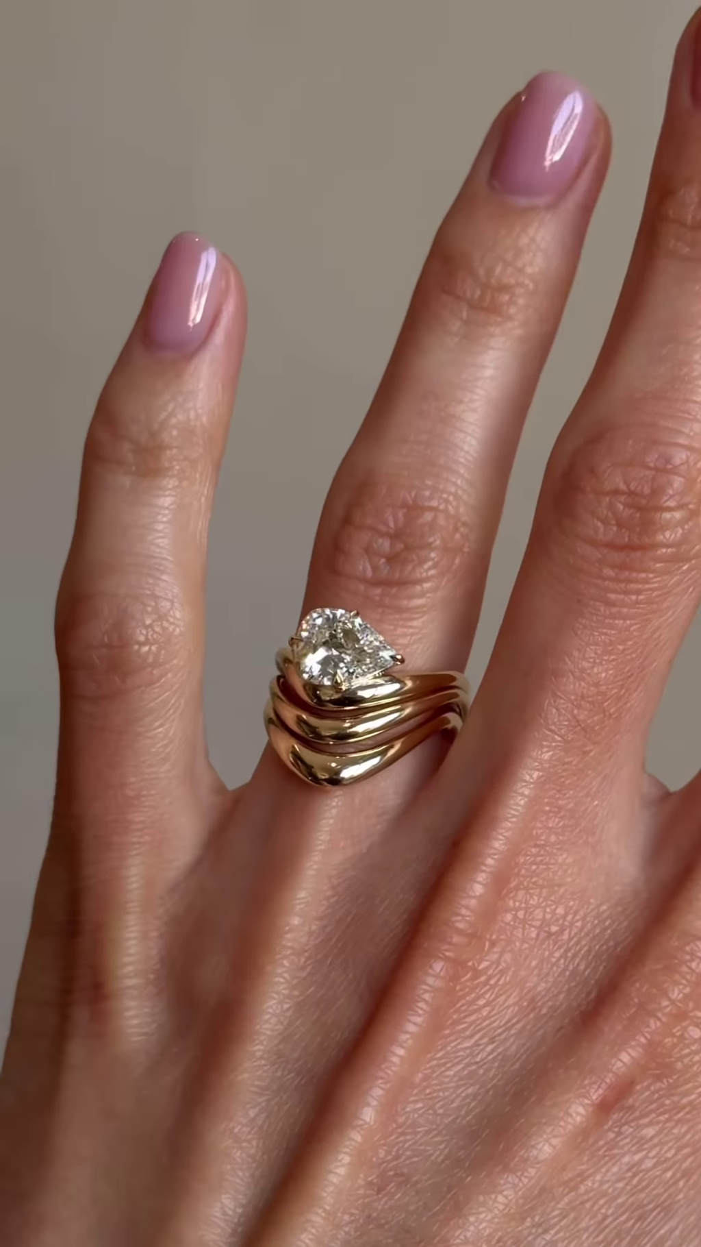 Sculptural Gold-Toned Ring with Wavy Design and Pear-Shaped Clear Gemstone