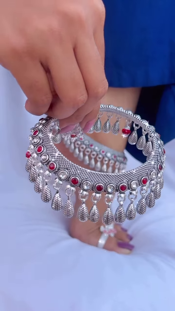 Ornate Silver-Toned Anklet with Red Gemstone Accents and Dangle Charms