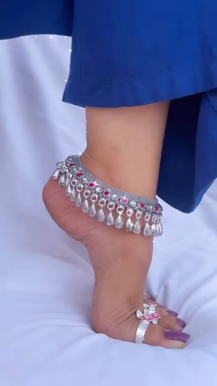 Ornate Silver-Toned Anklet with Red Gemstone Accents and Dangle Charms